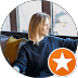Blonde woman in a dark sweatshirt looking out a window with an orange star icon.